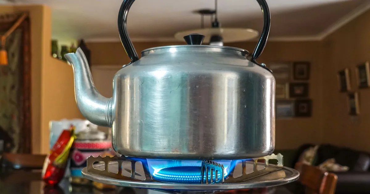 An aluminium kettle on a lit gas burner
