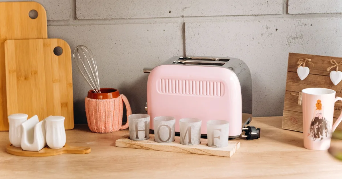 A pink retro toaster on a counter beside a HOME sign