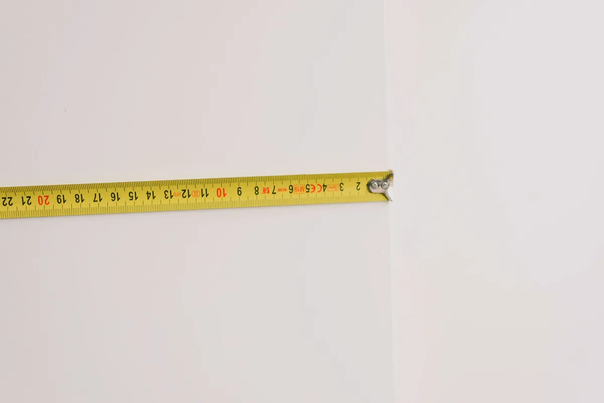 A tape measure extended across a plain white surface