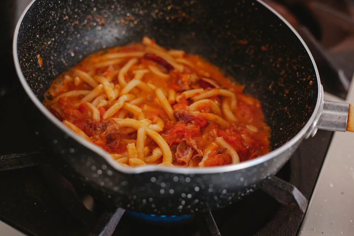 Pasta in tomato sauce in a dark nonstick pan