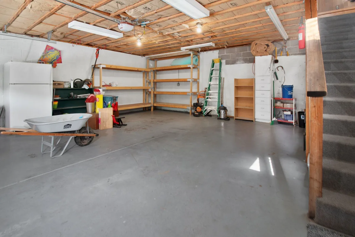 A tidy, empty garage with a concrete floor and plain white walls