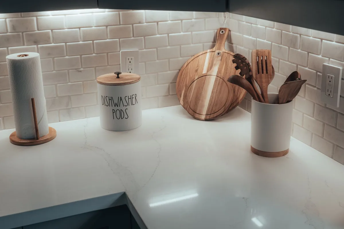 A tidy kitchen counter with utensils and a cutting board