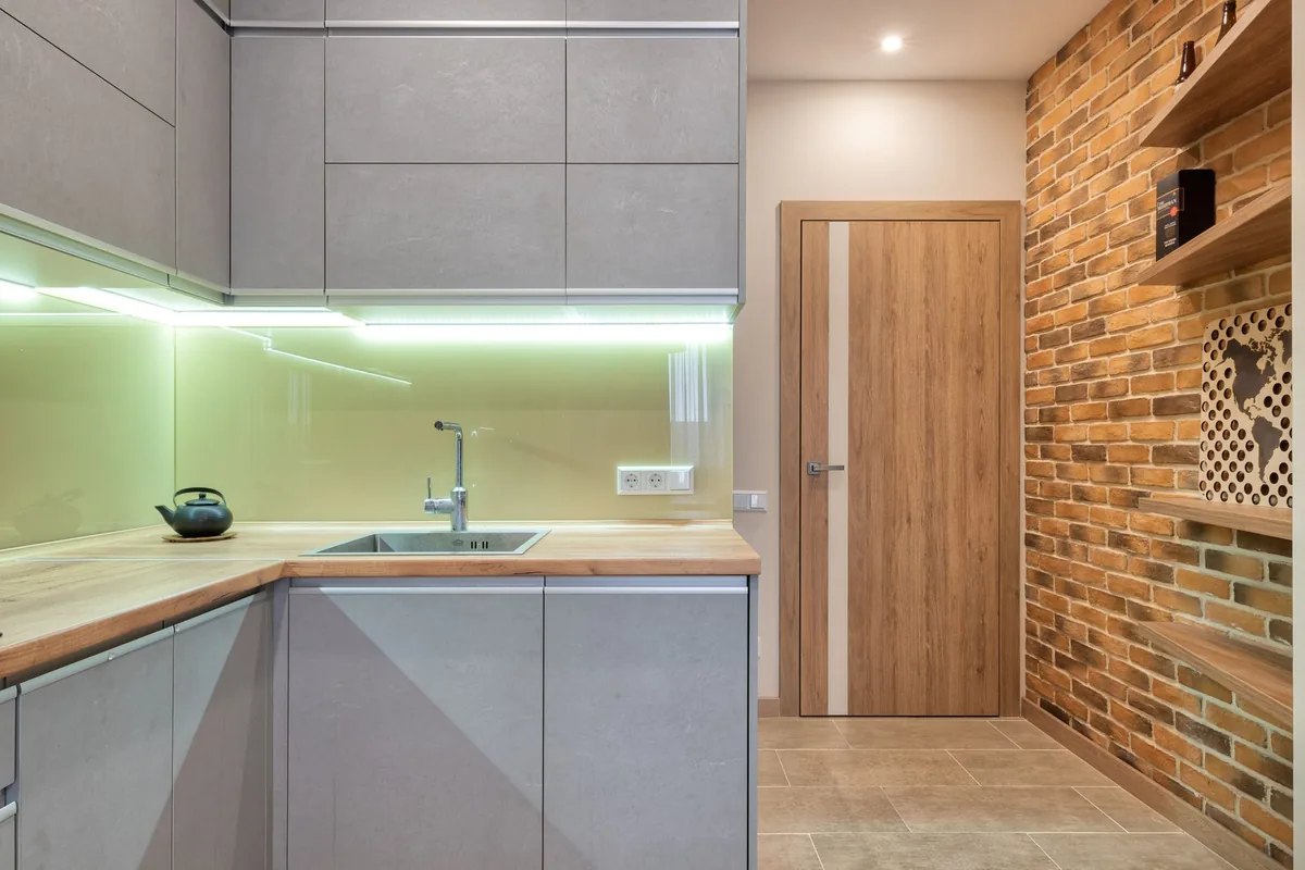 A tidy kitchen worktop beneath wall cabinets in morning light