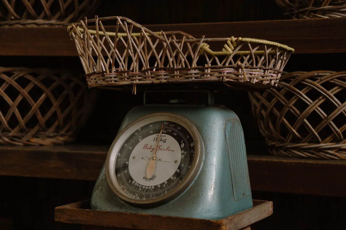 A vintage kitchen scale beneath a wicker basket