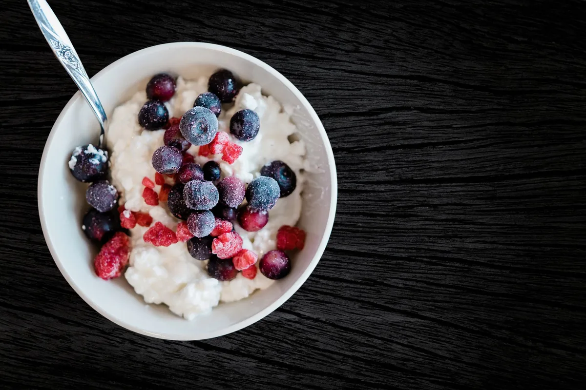 Frozen berries on cottage cheese in a white bowl