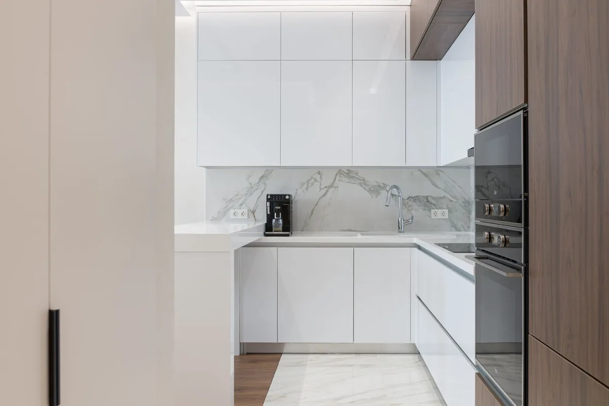 A white composite sink in a bright modern kitchen with pale cabinets