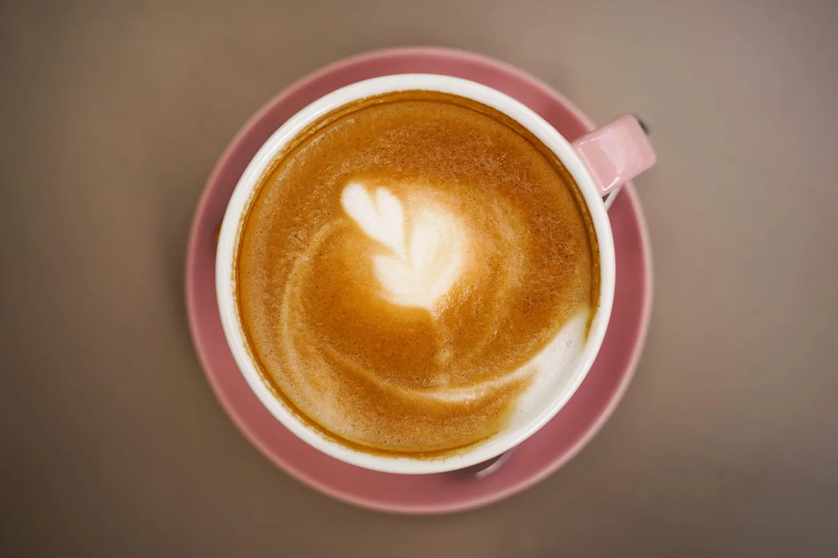 A white cup of cappuccino seen from above with a smooth layer of foam