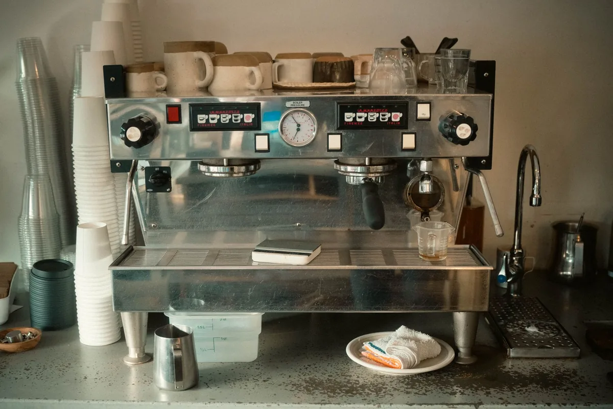 An espresso machine with cups stacked on top