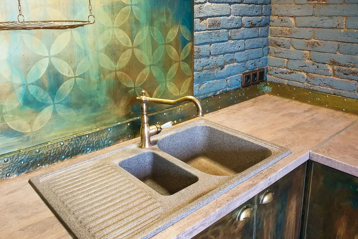 A double stone sink with a brass faucet