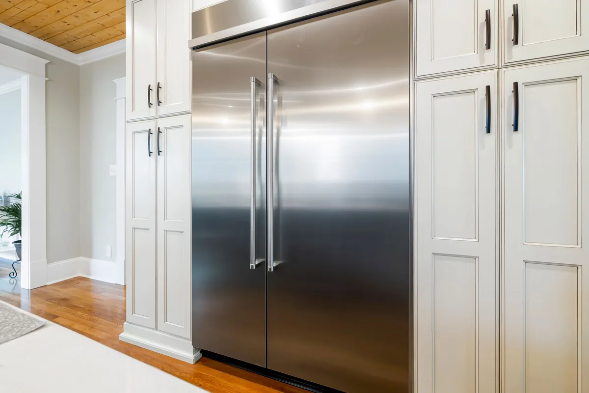 A stainless steel refrigerator in a white kitchen