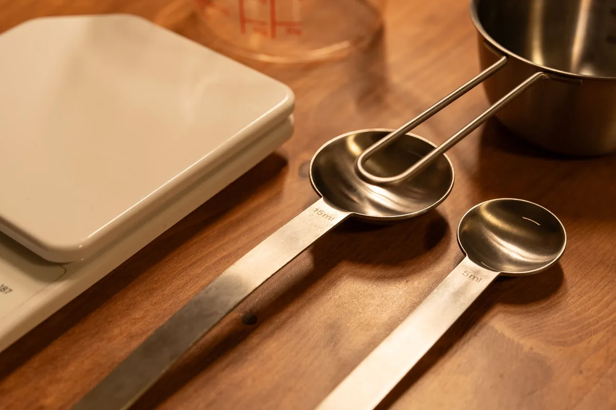 Measuring spoons beside a white kitchen scale