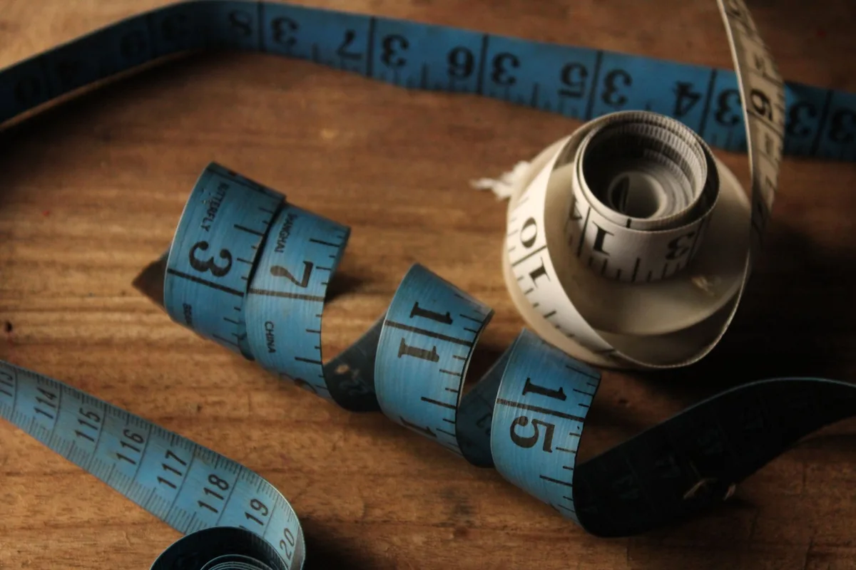 A blue cloth tape measure on a wooden table