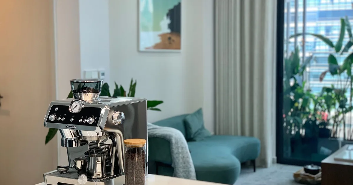 An espresso machine on a counter in a bright apartment