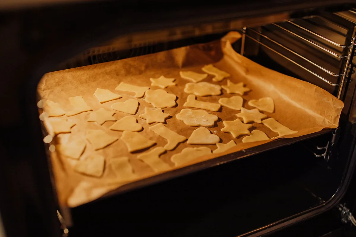 Cut-out cookies on parchment inside an oven