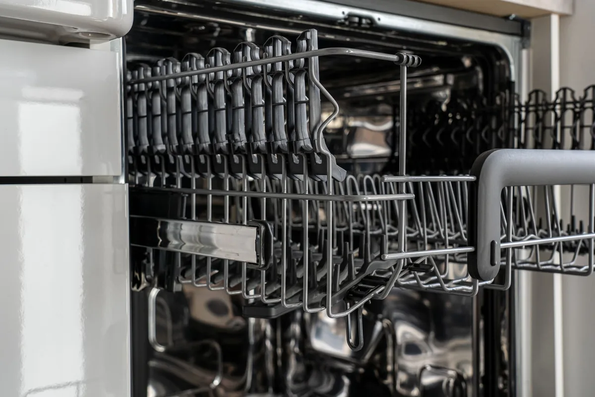 An open dishwasher with empty racks