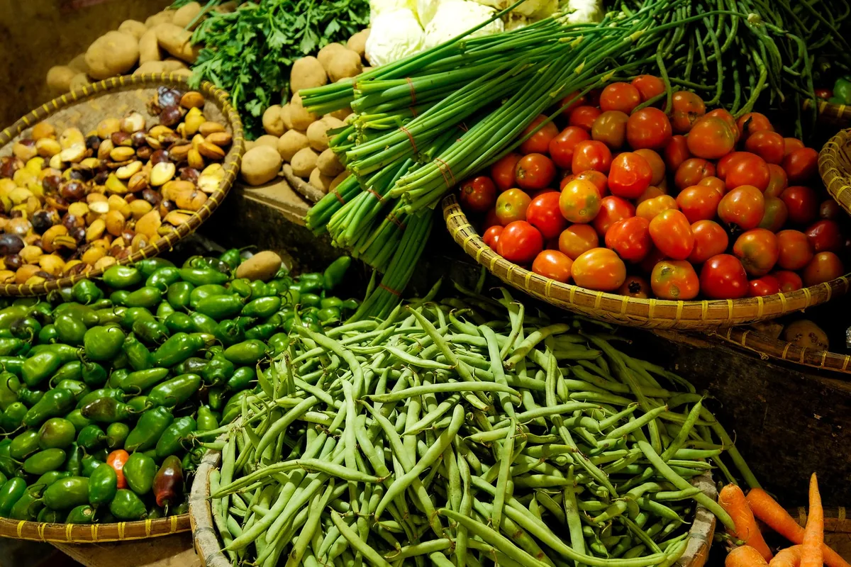 Baskets of tomatoes, beans and greens at a market