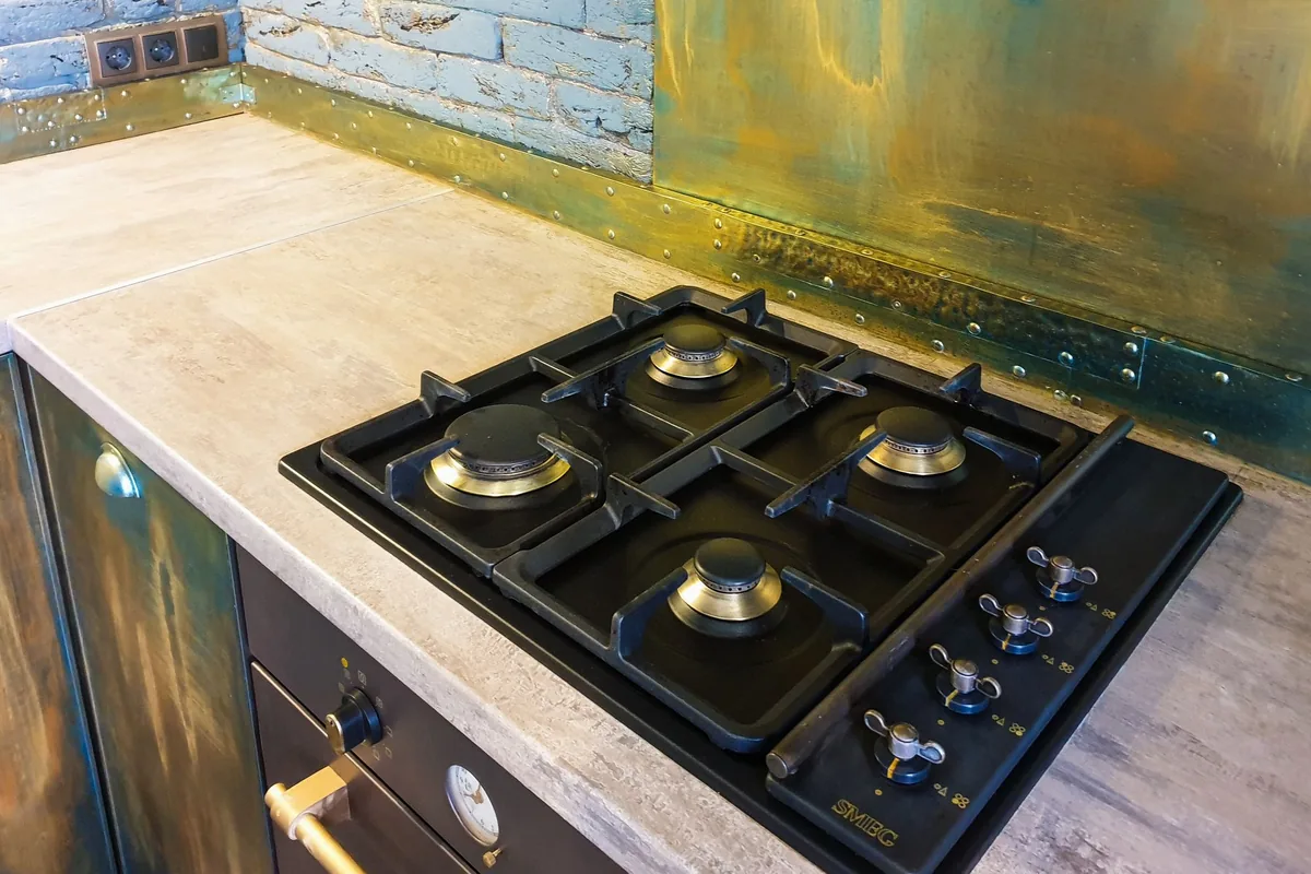 A black gas cooktop set into a stone counter