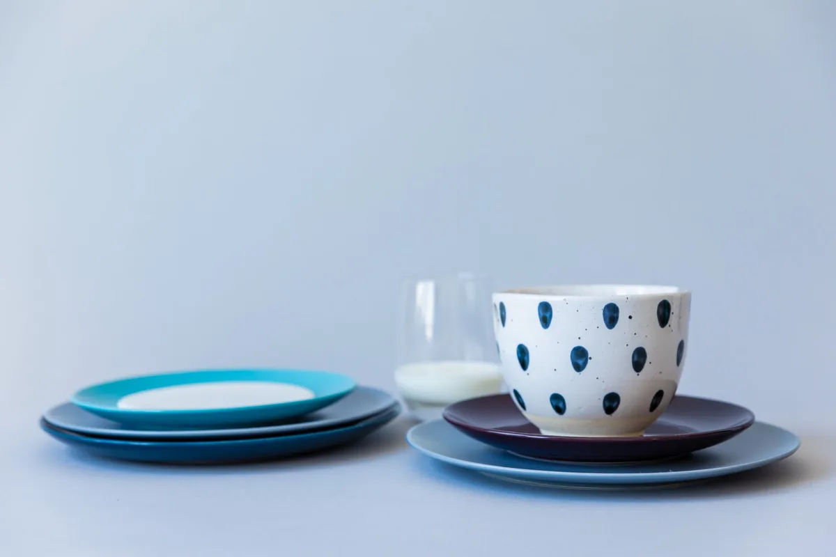 Blue plates and a patterned cup on a pale table