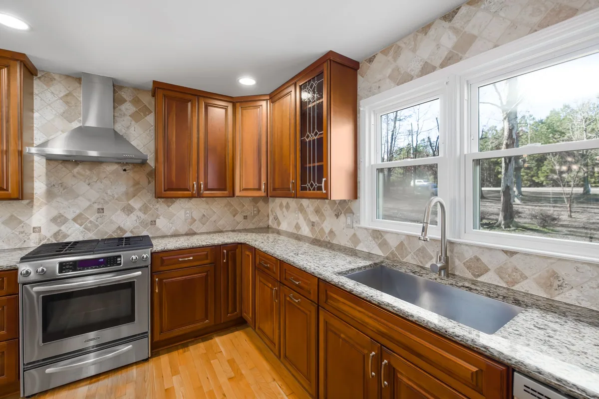 A wood kitchen with a stainless range and a chimney hood