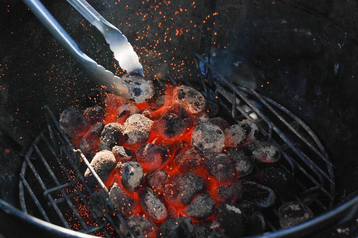 Charcoal glowing in a round kettle grill
