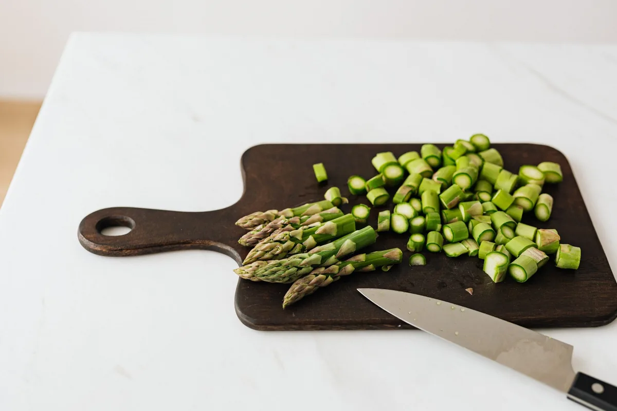 Chopped asparagus on a dark cutting board
