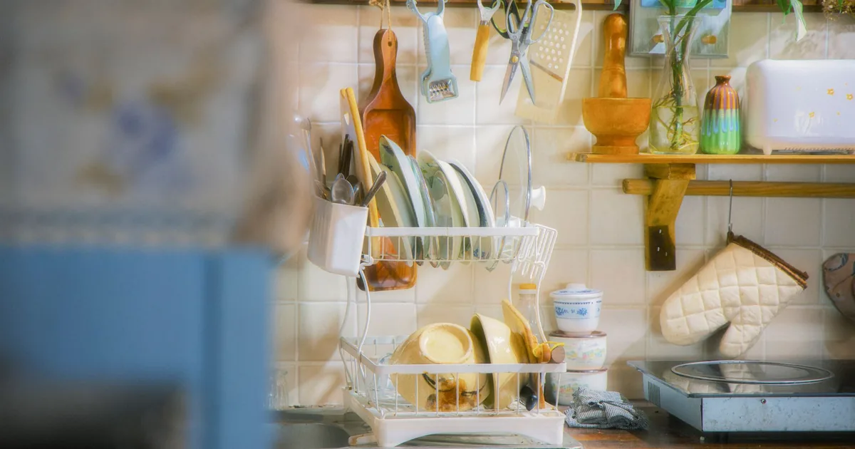 A wall dish rack and hanging utensils in a colourful kitchen