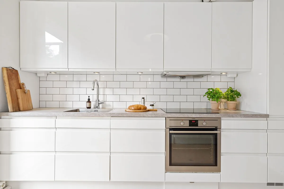 Clean white tiles on a kitchen backsplash above a countertop