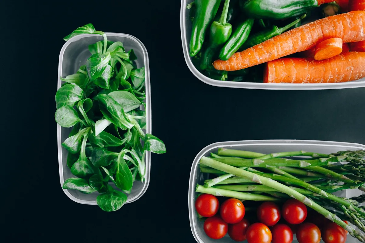 Clear containers of frozen mixed vegetables stacked in rows