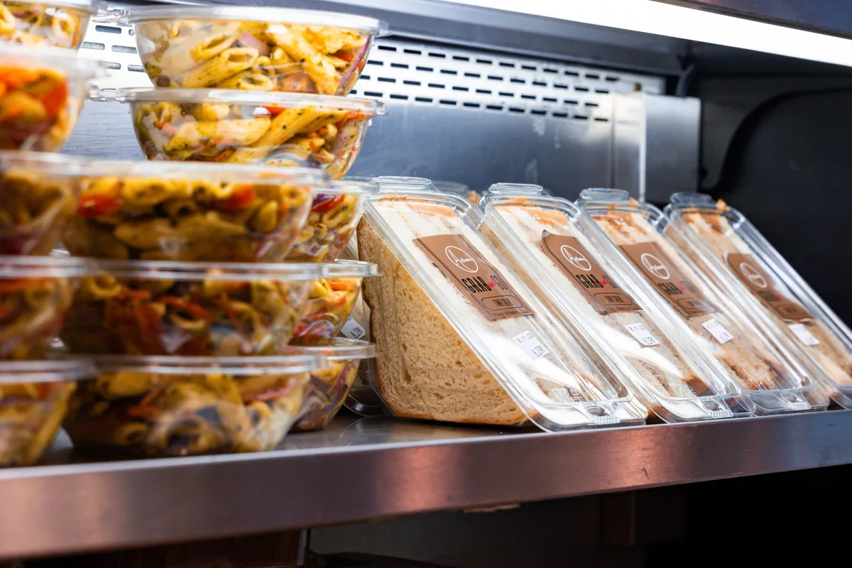 Clear containers of prepared food on a chilled shelf