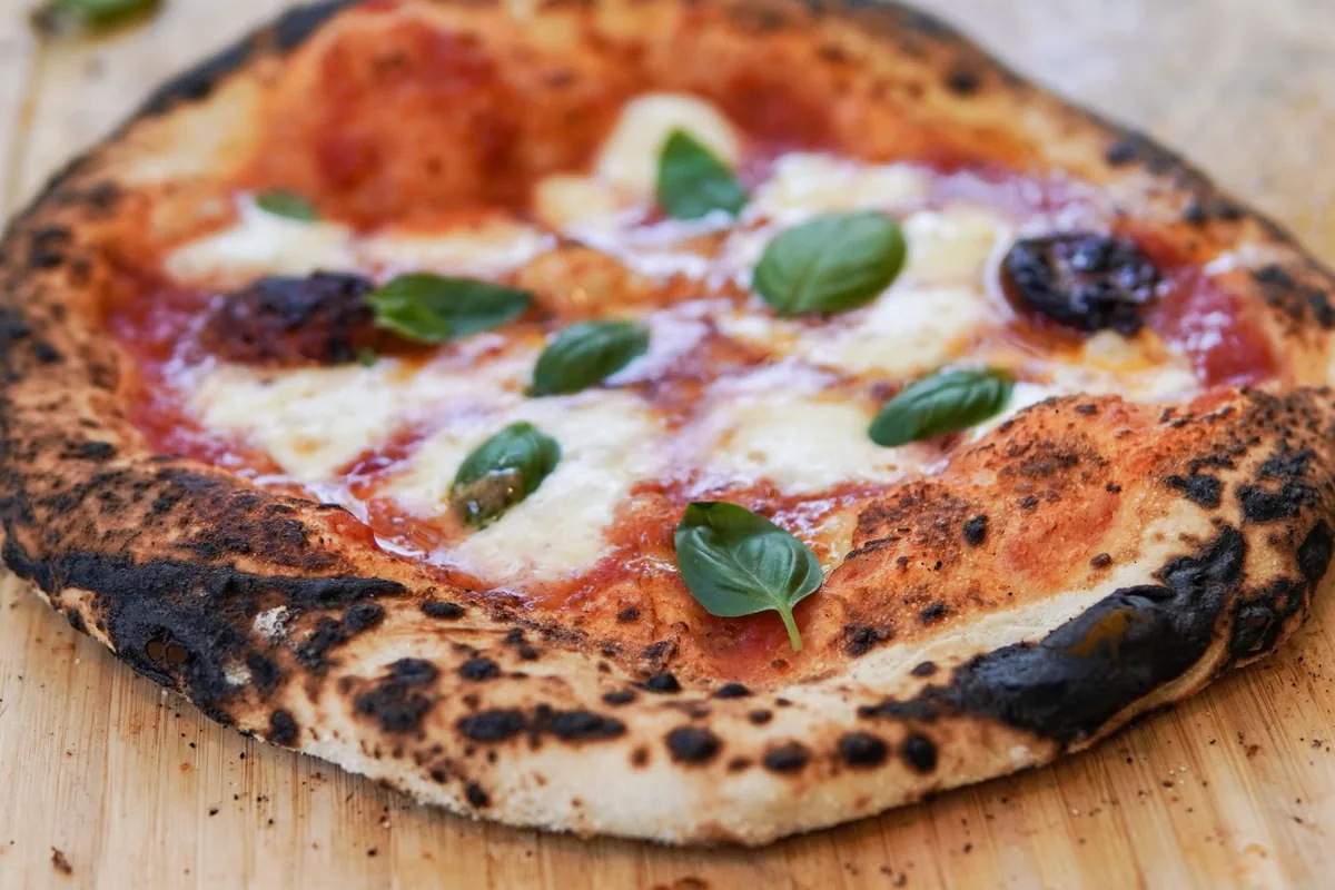 Close-up of a charred, puffy Neapolitan-style pizza crust