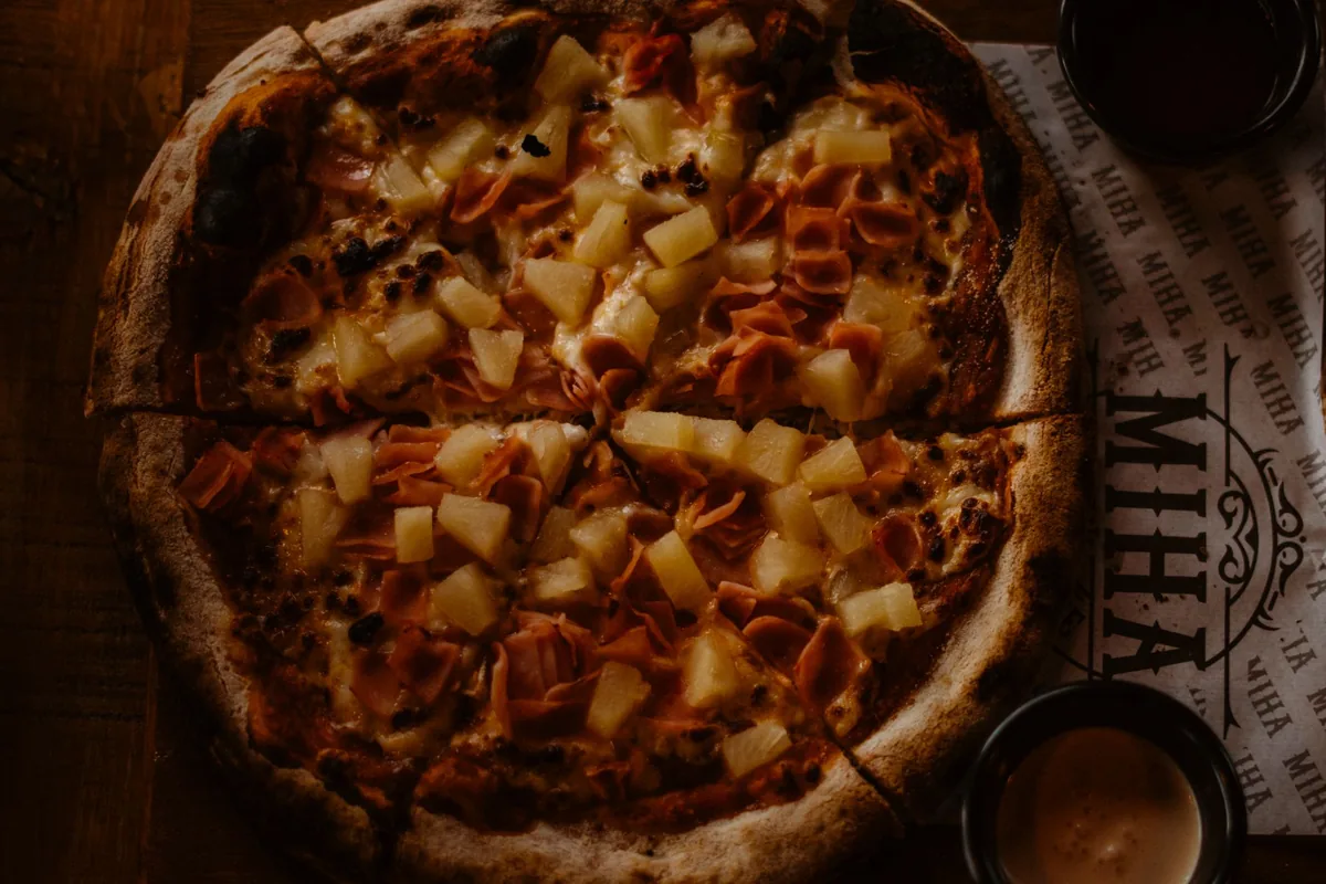 Close-up of a pizza topped with ham and pineapple