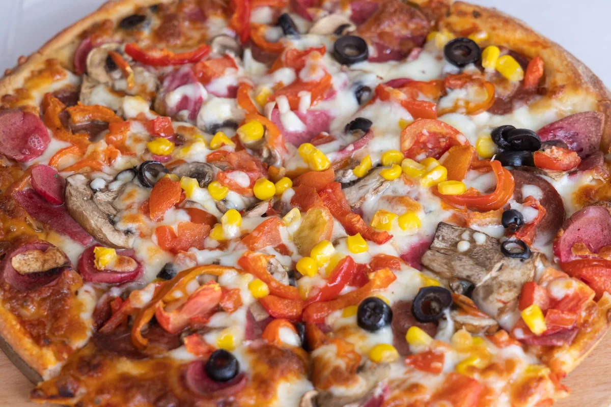 Close-up of a pizza topped with pepperoni, sausage and mushrooms
