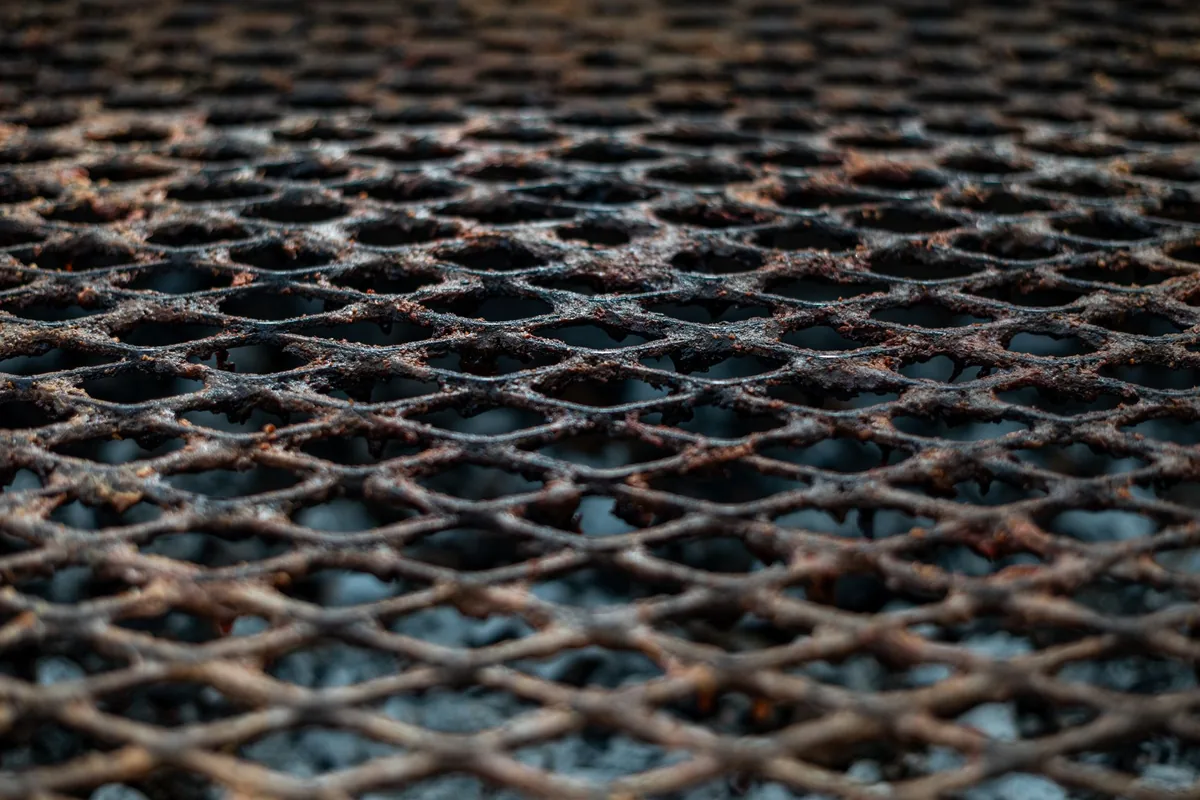 Close view of a clean metal barbecue cooking grate over a gas grill in daylight