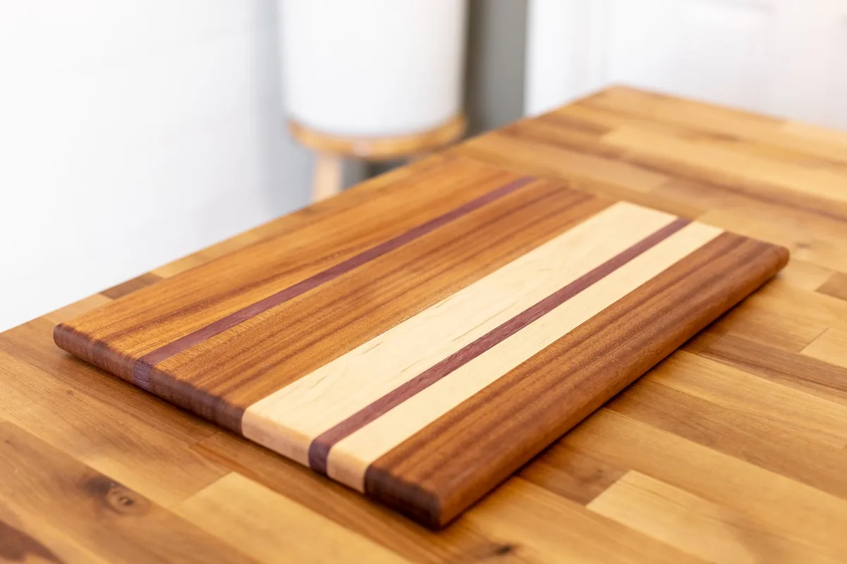 A striped hardwood cutting board on a butcher-block counter