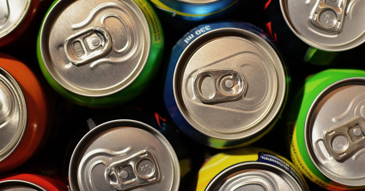 Colourful drink cans packed tightly, seen from above