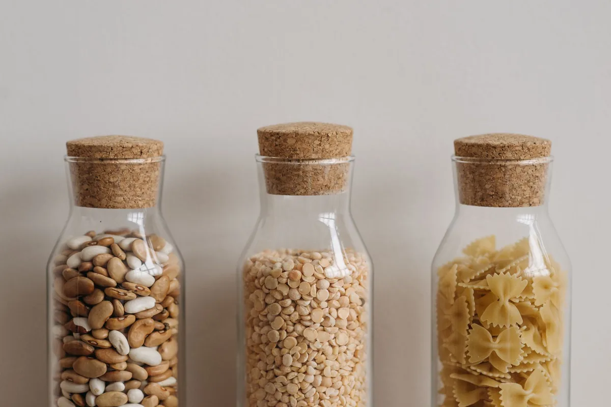 Cork-topped jars of beans and pasta on a counter