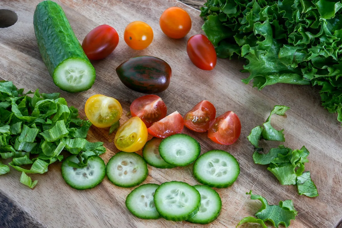 Cucumber slices and cherry tomatoes on a wooden board