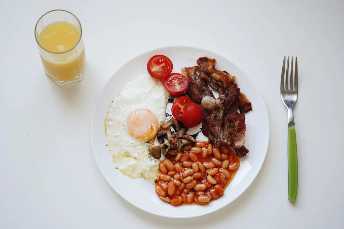 Eggs, bacon and beans on a white plate