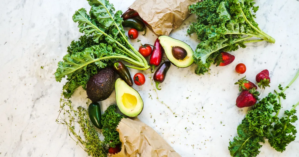 Fresh vegetables and herbs on a white surface
