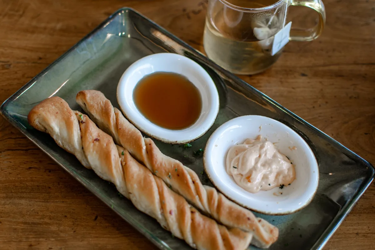 Garlic knots served with a cup of marinara sauce