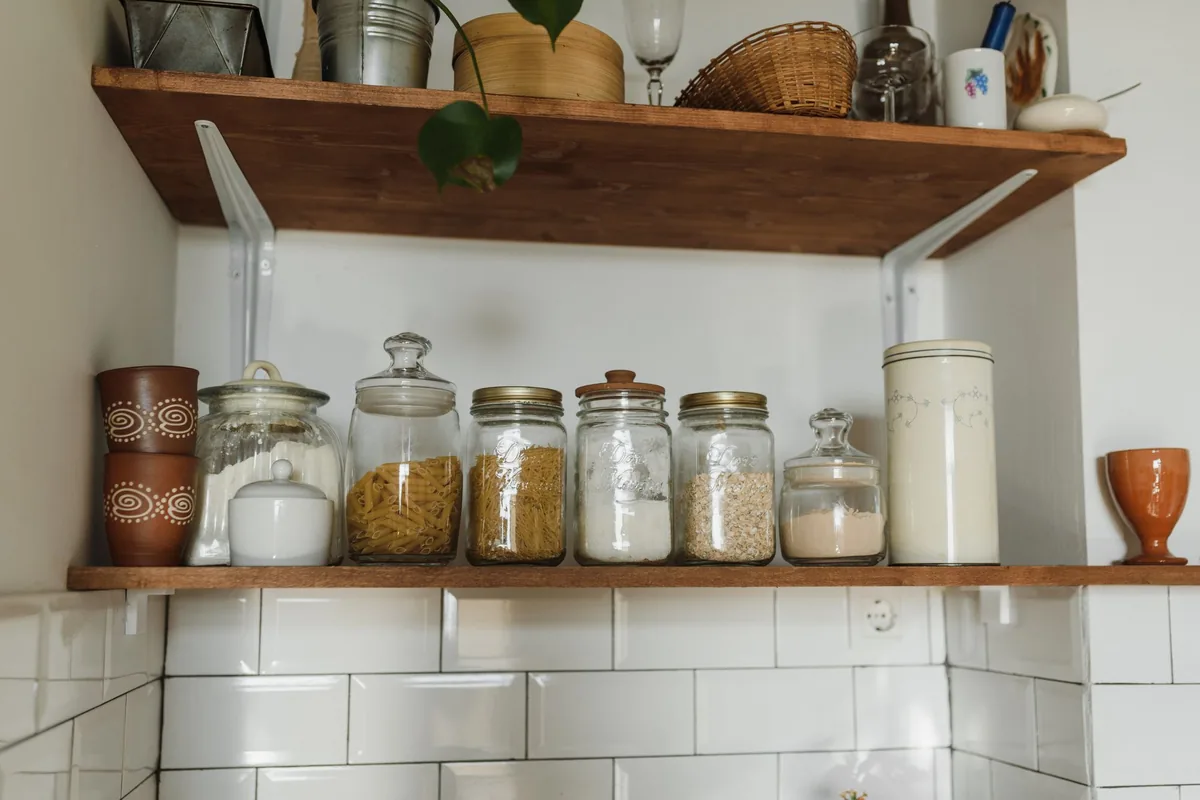 Glass jars of dry goods on open kitchen shelves