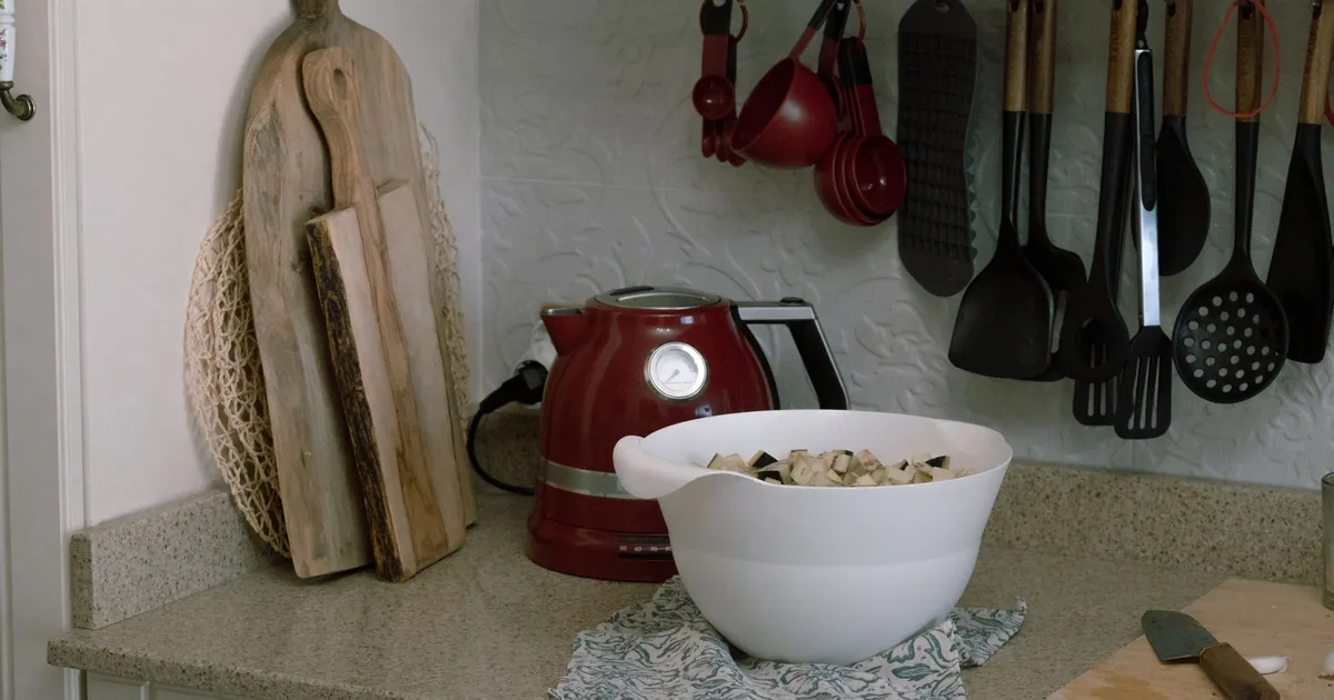 Hanging whisks and utensils above a counter with a stand mixer