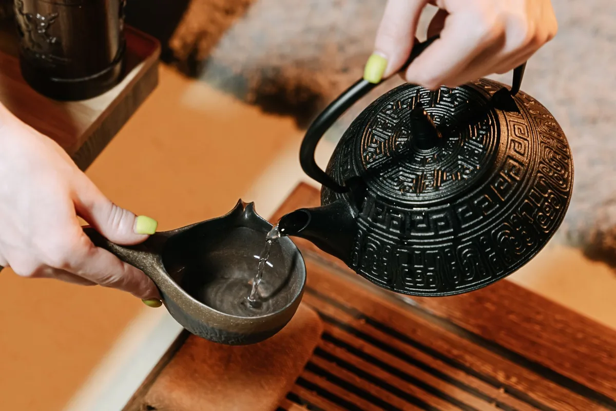 Hot water being poured from a kettle into a teapot