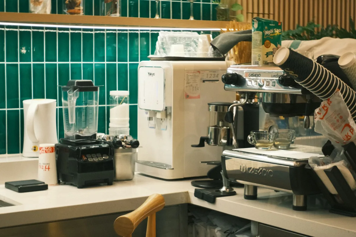 Kitchen appliances including a blender on a green-tiled counter
