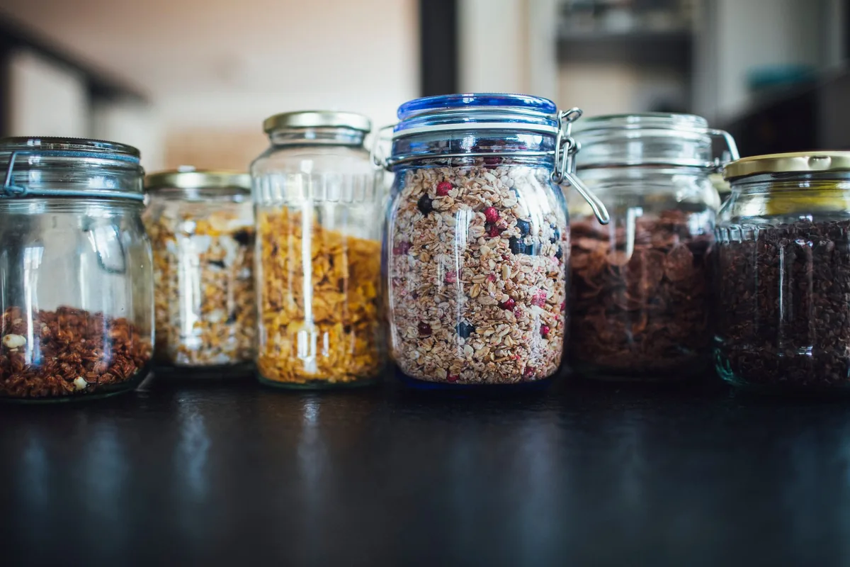 Mason jars of cereals and grains on a dark counter