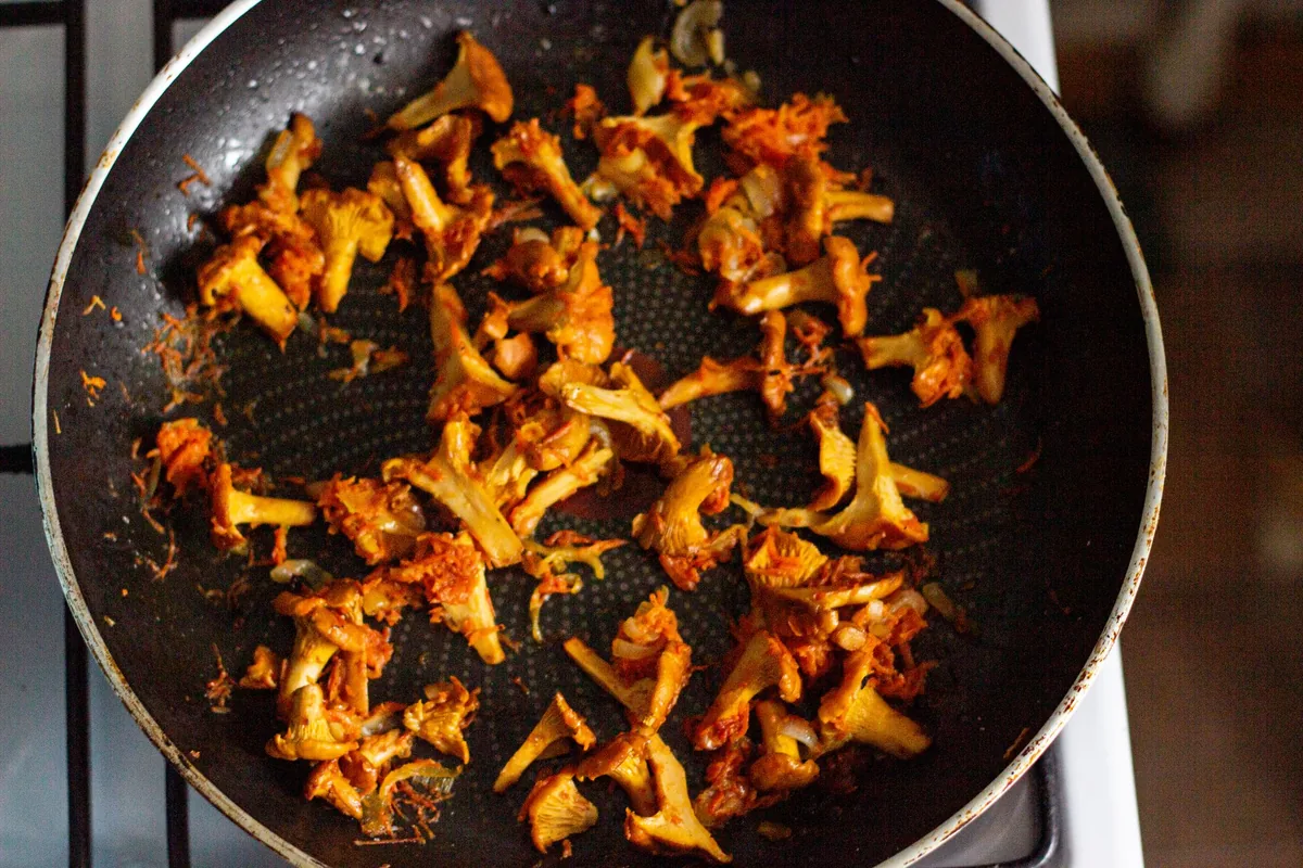 Mushrooms browning in a dark nonstick pan