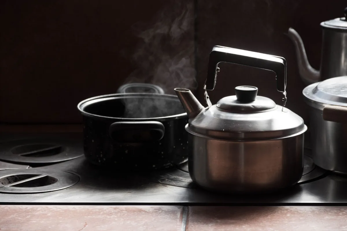 Polished stainless steel pans resting on a clean cooktop