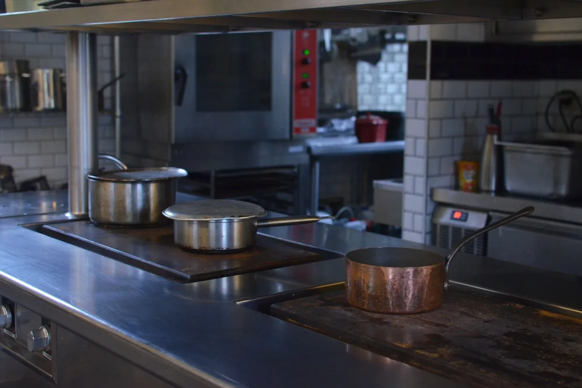 Pots on a commercial range in a steel kitchen