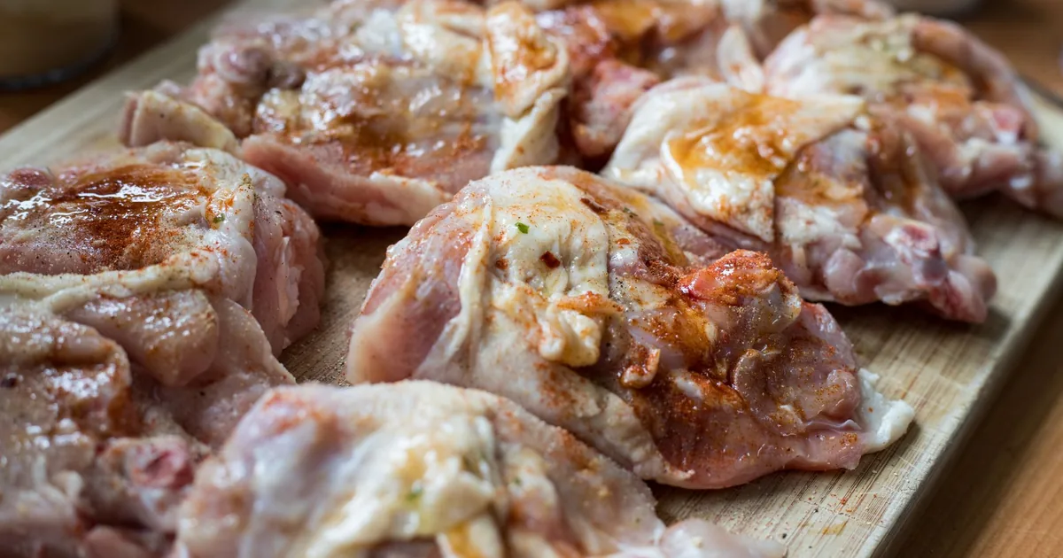 Raw chicken pieces on a wooden board