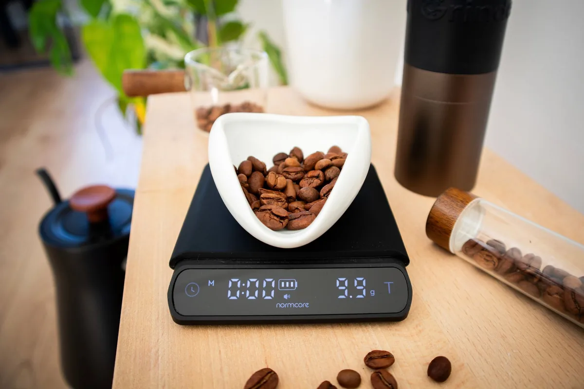 Roasted coffee beans being weighed on a digital kitchen scale
